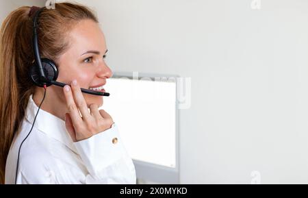 Femme agent de service à la clientèle dans le casque parlant en ligne avec le client. Banque D'Images