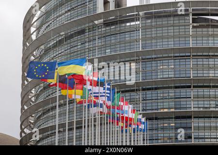 DAS Europaparlament in Straßburg Vor dem Gebäude des Europäischen Parlaments in Straßburg flattern die Flaggen der 27 eu-Mitgliedsstaaten sowie die Europafahne und die Flagge der Ukraine im kräftigen Wind. Straßburg Contades Nord Bas-Rhin Frankreich *** le Parlement européen à Strasbourg les drapeaux des 27 états membres de l'UE ainsi que le drapeau européen et le drapeau de l'Ukraine flottent dans le vent fort devant le bâtiment du Parlement européen à Strasbourg Contades Nord Bas Rhin France 20240409-6V2A0250 Banque D'Images