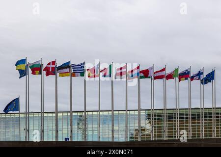 DAS Europaparlament in Straßburg Vor dem Gebäude des Europäischen Parlaments in Straßburg flattern die Flaggen der 27 eu-Mitgliedsstaaten sowie die Europafahne und die Flagge der Ukraine im kräftigen Wind. Straßburg Contades Nord Bas-Rhin Frankreich *** le Parlement européen à Strasbourg les drapeaux des 27 états membres de l'UE ainsi que le drapeau européen et le drapeau de l'Ukraine flottent dans le vent fort devant le bâtiment du Parlement européen à Strasbourg Contades Nord Bas Rhin France 20240409-6V2A0328 Banque D'Images