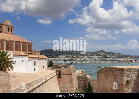 Les murs historiques du château d'Eivissa encadrent une vue imprenable sur le port animé d'Ibiza, mélangeant l'ancien avec le nouveau au milieu des eaux bleues sereines et du h roulant Banque D'Images