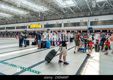 Les gens attendent l'ouverture des comptoirs d'enregistrement au terminal 2 de l'aéroport international d'Antalya à Antalya, en Turquie Banque D'Images