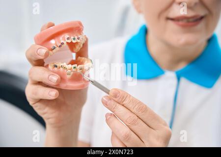 Orthodontiste expérimenté pointant une dent en mauvaise position Banque D'Images
