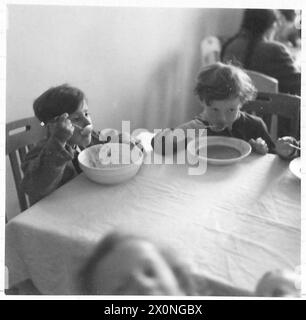 LA LIBÉRATION DU CAMP DE CONCENTRATION DE BERGEN-BELSEN, AVRIL 1945 - les enfants polonais, néerlandais, français et hongrois peuvent enfin s'asseoir pour manger dans des salles à manger impeccables et ici certains d'entre eux sont vus profiter de leur repas de mi-journée. Les enfants du camp n° 2 devenu hôpital et centre d'évacuation du camp n° 1 sont très bien pris en charge. La majorité des enfants ici sont soit juifs, soit d'origine juive Banque D'Images