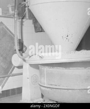 UNE BOULANGERIE MODERNE : LE TRAVAIL DE WONDER BAKERY, WOOD GREEN, LONDRES, ANGLETERRE, ROYAUME-UNI, 1944 - Un travailleur de la boulangerie Wonder, Wood Green, utilise la peseuse automatique de farine Banque D'Images