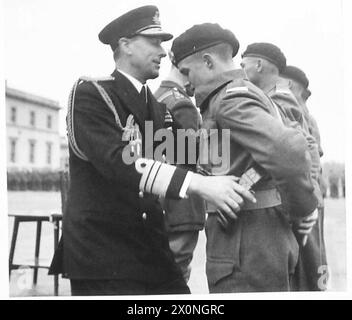 LE VICE-AMIRAL LORD LOUID MOUNTBATTEN PREND LE SALUT AU DÉFILÉ DE LA R.A.C. - Sam Browne Belts sont présentés à des cadets exceptionnels. Le vice-amiral Lord Louis Mountbatten est vu ajuster la ceinture d'un cadet. Négatif photographique, Armée britannique Banque D'Images