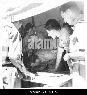 Sa Majesté le Roi visite un aérodrome de chasse avancé, observant les pilotes pendant le briefing et étudiant les cibles assignées, illustrant l'inspection royale de la Force aérienne du désert en Italie. Banque D'Images
