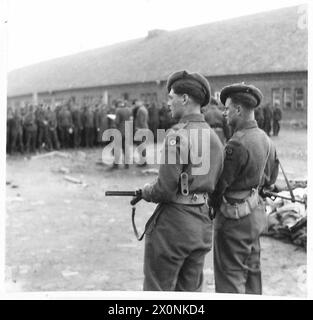 ILLUSTRATIONS POUR DES HISTOIRES PAR L'OFFICIER OBSERVATEUR : 15E DIVISION ÉCOSSAISE - GNR.Whitaker de Manchester [à gauche] et GNR.Riley de Poplar, Londres, sur la garde des hommes SS au camp de Neuengamme [numéro de série 709] Banque D'Images