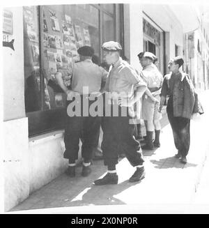 JOURNAL DE L'ARMÉE - Une scène quotidienne dans la rue Georges Clemenceau, Constantine. Les soldats s'arrêtent pour lire les derniers bulletins et pour voir le sct. Les dernières photos des événements dans le théâtre de guerre nord-africain. Négatif photographique, Armée britannique Banque D'Images