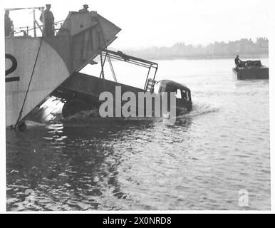 Un véhicule 4x4 G.S. Ford de trois tonnes sort d'un engin de débarquement. Un véhicule Alligator est également visible. Photographié par l'armée britannique. Banque D'Images