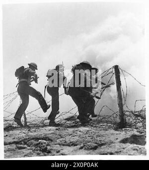 ENTRAÎNEMENT À L'INVASION PAR LES TROUPES DES NATIONS ALLIÉES - sur la plage de forts enchevêtrements de fils barbelés sont rencontrés et brisés alors que les troupes balaient vers l'avant. Négatif photographique, Armée britannique Banque D'Images