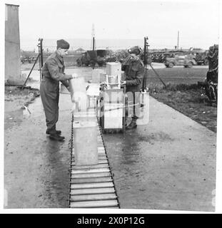 PHOTOGRAPHIES PRISES DANS Un CENTRE DE REMPLISSAGE D'ESSENCE MOBILE R.A.S.C. montrant le retrait des bidons de la machine à laver et leur placement sur le convoyeur menant à la remplisseuse portable. Négatif photographique, Armée britannique Banque D'Images