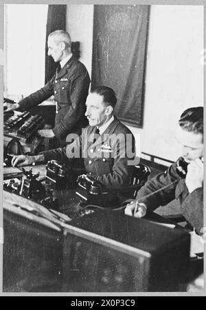 Officier de contrôle à son bureau à l'intérieur d'une tour de contrôle de station de la RAF, supervisant le trafic aérien et la coordination opérationnelle. Banque D'Images