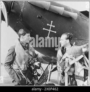 HOMMES ET MACHINES DE L'ESCADRON DE CHASSE "CHINA BRITISH" - pour l'histoire voir CH.5477 photos - le C.O. [à gauche] en conversation avec un pilote français libre de son escadron, dont l'ouragan porte l'emblème de la Croix de Lorraine. Négatif photographique, Royal Air Force Banque D'Images