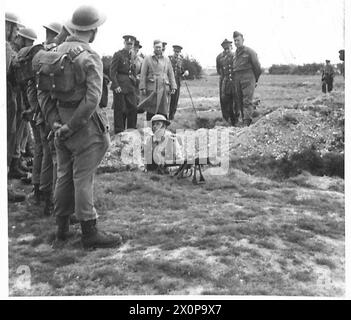 LE SECRÉTAIRE D'ÉTAT À LA GUERRE REND VISITE AUX TROUPES - Sir James Grigg, secrétaire d'État à la guerre, intéressé par un pistolet PIAT. Négatif photographique, Armée britannique Banque D'Images