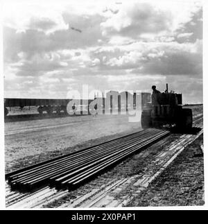 PHOTOS DE LA CONSTRUCTION Western DESERTRAILWAY - des longueurs de rails sont traînées par un tracteur du point de déchargement et prises à la partie avant de la construction. Ce tracteur traîne 18 longueurs de rail sur le sable. Négatif photographique, Armée britannique Banque D'Images