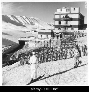 Les troupes de ski de l'école de ski défilent devant le quartier général de leur hôtel pendant la formation. Banque D'Images