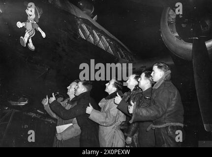 RAF BOMBER COMMAND 1940 - Un équipage de Wellington admire l'œuvre d'art Pinocchio sur le côté de leur avion, le 5 septembre 1940 Banque D'Images