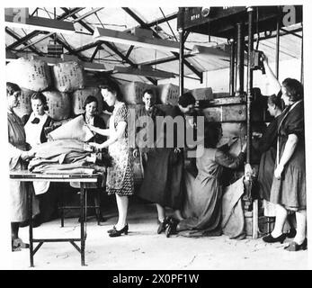 ROYAL ORDINANCE CORPS : DÉPÔT DE MAGASINS DE RETOUR - au travail autour de la machine à balles, montrant les vêtements des soldats reconditionnés en balles prêts à être réédités. Négatif photographique, Armée britannique Banque D'Images