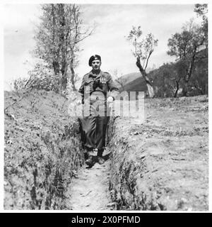 Négatif photographique montrant le général Władysław Anders marchant dans une tranchée lors de sa visite au poste d'observation de la 78e division d'infanterie à Cervaro, près de Cassino, Italie, 1943-1945, illustrant l'inspection militaire et les opérations sur le terrain. Banque D'Images