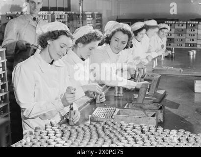 LES FEMMES SUR LE FRONT INTÉRIEUR 1939 - 1945 - les femmes dans l'industrie : travailleuses à temps partiel, populairement connu sous le nom de "Housewives Brigade" dans une usine de remplissage de coquilles Royal Ordnance. Ils passaient environ quatre heures par jour à fabriquer des fusibles et portaient un badge rouge, blanc et bleu sur leur casquette afin de pouvoir les distinguer des travailleurs à temps plein Banque D'Images