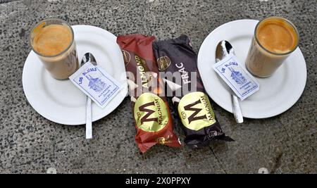 wo magnum barres de crème glacée, deux verres de café sur assiettes avec cuillères, sachets de sucre, Banque D'Images