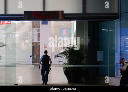 Sydney, Australie. 13 avril 2024. Des policiers gardent l'entrée d'un centre commercial après une attaque au couteau à Sydney, Australie, le 13 avril 2024. Six personnes ont été tuées dans une attaque au couteau dans un centre commercial de Sydney en Australie samedi et l'agresseur a été abattu par la police, a déclaré la police. Crédit : ma Ping/Xinhua/Alamy Live News Banque D'Images