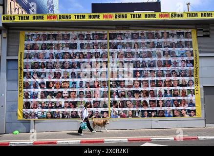 Tel Aviv, Israël. 13 avril 2024. Une femme passe devant des photos d’otages israéliens retenus captifs à Gaza par le Hamas, dans une rue de tel Aviv, le samedi 13 avril 2024. Photo de Debbie Hill/ crédit : UPI/Alamy Live News Banque D'Images