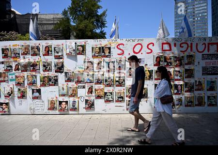 Tel Aviv, Israël. 13 avril 2024. Les gens passent devant des photos d'otages israéliens retenus captifs à Gaza par le Hamas, samedi 13 avril, sur la place des otages de tel Aviv. Photo de Debbie Hill/ crédit : UPI/Alamy Live News Banque D'Images