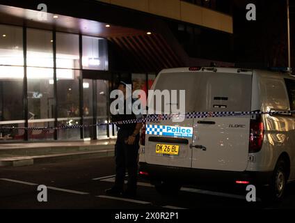 Sydney, Australie. 13 avril 2024. Un policier monte la garde près d'un centre commercial après une attaque au couteau à Sydney, Australie, le 13 avril 2024. Six personnes ont été tuées dans une attaque au couteau dans un centre commercial de Sydney en Australie samedi et l'agresseur a été abattu par la police, a déclaré la police. Crédit : ma Ping/Xinhua/Alamy Live News Banque D'Images