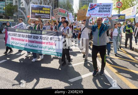 Séoul, Corée du Sud. 13 avril 2024. Des partisans pro-palestiniens tiennent une banderole et des pancartes lors d'une manifestation dans le centre de Séoul. Des partisans pro-palestiniens ont défilé dans le centre-ville de Séoul appelant à la fin du génocide maintenant! Et pas d'invasion terrestre de Rafah!. Crédit : SOPA images Limited/Alamy Live News Banque D'Images