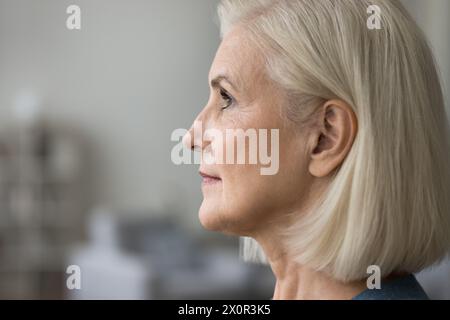 Vue rapprochée du profil d'une femme blonde mature sérieuse regardant droite Banque D'Images