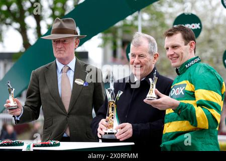 Paul Townend (à droite), l'entraîneur Willie Mullins (à gauche) et propriétaire du cheval I am Maximus, J P McManus avec le trophée après avoir remporté le Randox Grand National handicap Chase le troisième jour du Randox Grand National Festival 2024 à l'hippodrome d'Aintree, Liverpool. Date de la photo : samedi 13 avril 2024. Banque D'Images