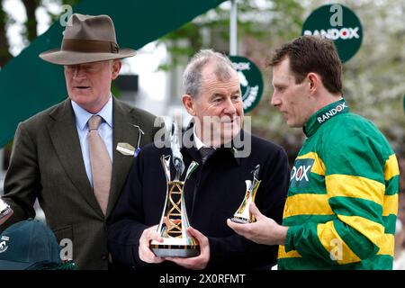 Paul Townend (à droite), l'entraîneur Willie Mullins (à gauche) et propriétaire du cheval I am Maximus, J P McManus avec le trophée après avoir remporté le Randox Grand National handicap Chase le troisième jour du Randox Grand National Festival 2024 à l'hippodrome d'Aintree, Liverpool. Date de la photo : samedi 13 avril 2024. Banque D'Images