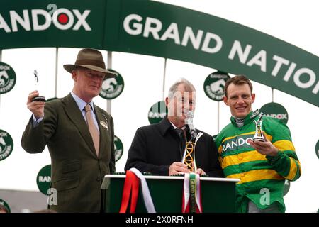 Paul Townend (à droite), l'entraîneur Willie Mullins (à gauche) et propriétaire du cheval I am Maximus, J P McManus avec le trophée après avoir remporté le Randox Grand National handicap Chase le troisième jour du Randox Grand National Festival 2024 à l'hippodrome d'Aintree, Liverpool. Date de la photo : samedi 13 avril 2024. Banque D'Images