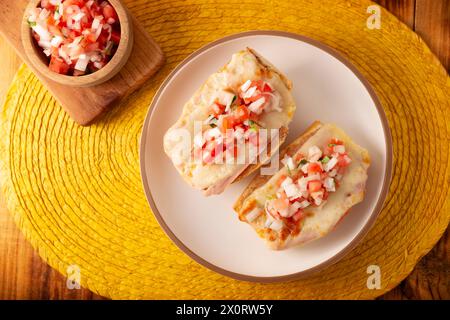 Molletes. Recette mexicaine à base de pain bolillo fendu dans le sens de la longueur, tartiné de haricots frits et de fromage gratiné, ajoutant de la sauce Pico de gallo et un peu de pro Banque D'Images