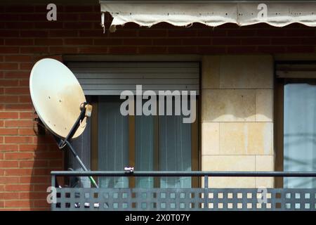 Antenne parabolique sur un balcon urbain, symbolisant la fusion de la technologie de pointe et de l'architecture résidentielle, dans un contexte de vie urbaine moderne. Banque D'Images