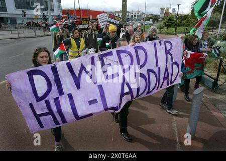 Rhyl, Royaume-Uni. 13 avril 2024. Manifestants vus avec une banderole exprimant leur opinion pendant la manifestation. Plus de 150 partisans pro-palestiniens de partout au pays de Galles ont manifesté dans les rues pour exiger un cessez-le-feu à Gaza et mettre fin au génocide. Crédit : SOPA images Limited/Alamy Live News Banque D'Images