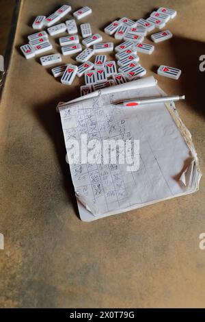 171 double neuf tuiles domino style -drapeau cubain sur le revers- dispersé sur la table, et le carnet avec les résultats du jeu. Viñales-Cuba. Banque D'Images