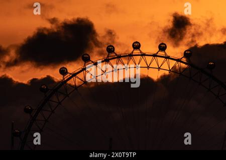 Londres, Royaume-Uni. 13 avril 2024. Météo Royaume-Uni : coucher de soleil spectaculaire près de London Eye Grande roue terminant un samedi chaud que le met Office confirme comme jour le plus chaud de l'année tant que les températures montent au-dessus de la moyenne. Les températures ont dépassé 21 °C dans au moins deux endroits - St James Park, dans le centre de Londres, et Northolt, dans l'ouest de Londres - alors qu'un panache d'air de l'Atlantique s'est déplacé du sud-ouest. Crédit : Guy Corbishley/Alamy Live News Banque D'Images