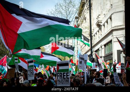 Londres, Royaume-Uni. 13 avril 2024. Les manifestants tiennent des drapeaux palestiniens pendant la marche de Palestine : arrêtez d'armer Israël. Les Londoniens ont rejoint la journée nationale d'action pour la Palestine alors qu'ils marchaient vers la place du Parlement pour exiger que le gouvernement britannique cesse d'armer Israël et appelle à un cessez-le-feu permanent. Crédit : SOPA images Limited/Alamy Live News Banque D'Images