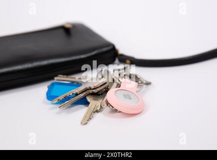 Gros plan des clés avec un AirTag pomme sur la table blanche Banque D'Images