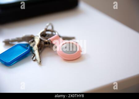 Gros plan des clés avec un AirTag pomme sur la table blanche Banque D'Images