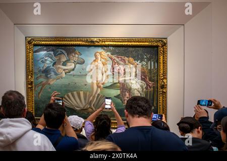 Florence, Italie - 04 avril 2024 : les visiteurs du Musée de la Galerie des Offices de Florence prennent des photos devant le célèbre tableau la naissance de Vénus b Banque D'Images