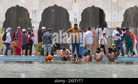 NEW DELHI, INDE - 13 AVRIL : les dévots se baignent dans l'étang sacré de Gurudwara Bangla Sahib à l'occasion du festival Baisakhi, le 13 avril 2024 à New Delhi, Inde. Baisakhi ou Vaisakhi, une fête populaire du printemps qui marque le premier jour du mois du Vaisakh, est célébrée avec beaucoup d'enthousiasme parmi les communautés hindoue, sikhe et bouddhiste. C'est le début du nouvel an pendjabi et sikh qui est célébré dans toute l'Inde, en particulier au Punjab et dans le nord de l'Inde. Le Baisakhi est observé le 13 avril de cette année, annonçant le début de la saison des récoltes au Pendjab. Il tombe le premier jour de Hin Banque D'Images