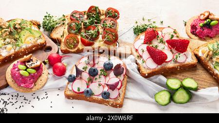 Petit déjeuner avec légumes. toasts, tomate, concombre, radis, avocat. Concept d'alimentation saine végétalienne. Panorama Banque D'Images