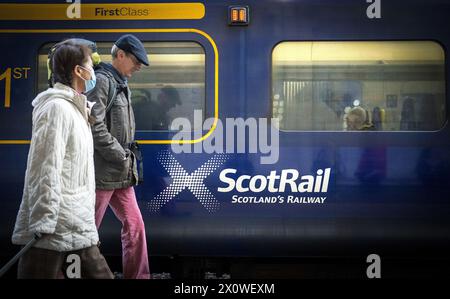 Photo du dossier datée du 23/05/22 de voyageurs passant devant un train ScotRail à la gare Waverley d'Édimbourg. Le parti travailliste écossais a exhorté les ministres à élaborer un plan de réduction des tarifs ferroviaires avant qu'un projet pilote visant à éliminer les pics de prix ne se termine. La proposition très louée devait prendre fin en mars, mais le gouvernement écossais l'a prolongée jusqu'à la fin du mois de juin. Date d'émission : dimanche 14 avril 2024. Banque D'Images