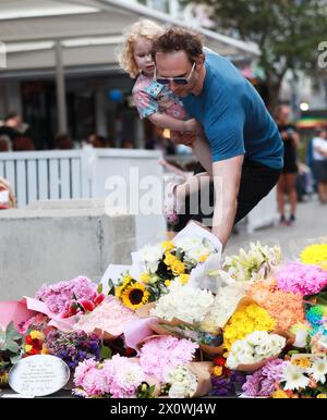 (240414) -- SYDNEY, 14 avril 2024 (Xinhua) -- Un homme dépose des fleurs avec sa fille devant le Westfield Shopping Centre à Bondi Junction à Sydney, Australie, le 14 avril 2024. Dimanche, la police australienne a identifié l'auteur d'un attentat à l'arme blanche dans un centre commercial de Sydney qui a tué six personnes, affirmant qu'aucun renseignement ne suggérerait que l'attaque était motivée par une idéologie. L'agresseur de l'attaque de samedi après-midi au Westfield Shopping Centre à Bondi Junction était Joel Cauchi, 40 ans, du Queensland, Nouvelle-Galles du Sud (Nouvelle-Galles du Sud), le commissaire adjoint de la police Anthony Cooke, a déclaré aux journalistes. (Xinhua/ma P Banque D'Images