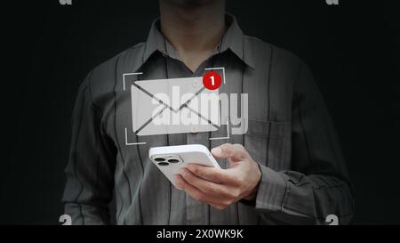 Main d'homme d'affaires à l'aide d'un smartphone pour envoyer un e-mail avec notification, concept de communication en ligne, icône d'e-mail, marketing par e-mail, envoi d'e-mail ou de newslet Banque D'Images