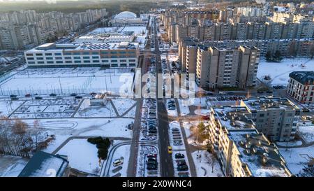 Photographie par drone de vieux bloc d'appartements à plusieurs étages, nouvelle école de l'autre côté et rue allant entre eux et couvert par la neige pendant l'hiver sunn Banque D'Images