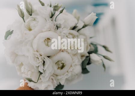 Un bouquet de fleurs blanches est tenu par une personne. Les fleurs sont disposées de manière à ce qu'elles ne soient pas trop proches les unes des autres, ce qui donne le Banque D'Images